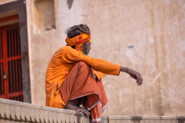 Varanasi, Uttar Pradesh, Hindistan - Kasım 2022: Tanınmayan Hint sadhu baba 'nın portresi gün doğumunda Varanasi şehrinde Ganj nehri kıyısındaki ghat üzerinde.