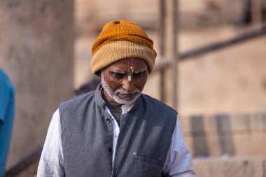 Varanasi, Uttar Pradesh, Hindistan - Kasım 2022: Tanınmayan Hint sadhu baba 'nın portresi gün doğumunda Varanasi şehrinde Ganj nehri kıyısındaki ghat üzerinde.