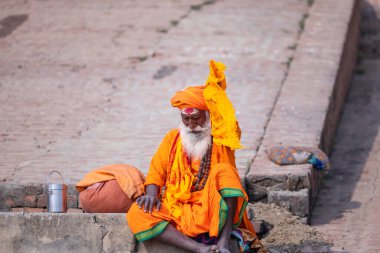 Varanasi, Uttar Pradesh, Hindistan - Kasım 2022: Tanınmayan Hint sadhu baba 'nın portresi gün doğumunda Varanasi şehrinde Ganj nehri kıyısındaki ghat üzerinde.