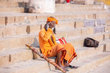 Varanasi, Uttar Pradesh, Hindistan - Kasım 2022: Tanınmayan Hint sadhu baba 'nın portresi gün doğumunda Varanasi şehrinde Ganj nehri kıyısındaki ghat üzerinde.