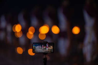 Rishikesh, Uttarakhand, India - October 2022: Portrait of hindu male priests performing river Gange aarti with fire flame in hands at triveni ghat to worship river ganges. Ganga aarti performed in night.