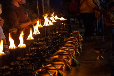 Rishikesh, Uttarakhand, India - October 2022: Portrait of hindu male priest performing river Gange aarti with fire flame in hand at triveni ghat to worship river ganges. Ganga aarti performed in night