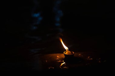 Fire flame at night with dark background during the ganga aarti rituals at river bank.