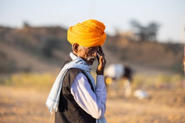 Pushkar, Rajasthan, India - November 2022: Pushkar Fair, camel trader in ethnic dress at fair ground during pushkar fair.