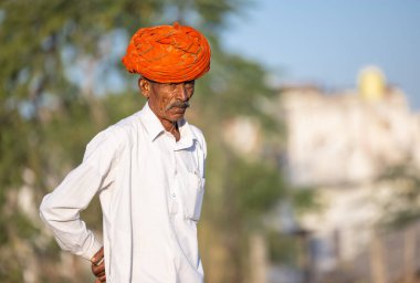 Pushkar, Rajasthan, India - November 2022: Pushkar Fair, camel trader in ethnic dress at fair ground during pushkar fair.