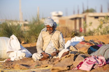 Pushkar, Rajasthan, India - November 2022: Pushkar Fair, camel trader in ethnic dress at fair ground during pushkar fair.