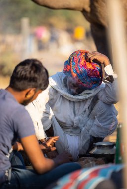 Pushkar, Rajasthan, India - November 2022: Pushkar Fair, Portrait of an camel trader in ethnic dress and rajasthani turban on fair ground during pushkar fair.