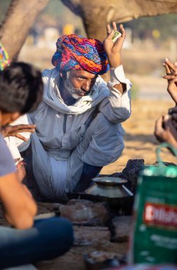 Pushkar, Rajasthan, India - November 2022: Pushkar Fair, Portrait of an camel trader in ethnic dress and rajasthani turban on fair ground during pushkar fair.
