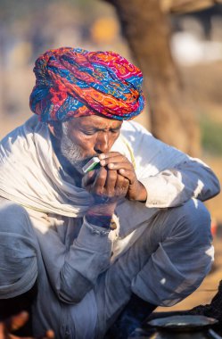 Pushkar, Rajasthan, India - November 2022: Pushkar Fair, Portrait of an camel trader in ethnic dress and rajasthani turban on fair ground during pushkar fair.