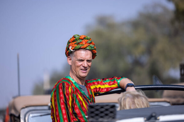 Bikaner, Rajasthan, India - January 2023: Camel Festival, Portrait of an rajasthani male with moustache, colorful turban wearing traditional colorful rajasthani dress. Rajput male of bikaner.