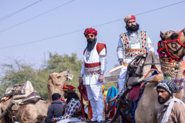 Bikaner, Rajasthan, India - January 2023: Camel Festival, Portrait of an young rajasthani male with beard and moustache wearing white traditional rajasthani dress and turban. Rajput male of bikaner.