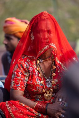 Bikaner, Rajasthan, India - January 2023: Camel festival, Portrait of an young and beautiful female in traditional rajasthani lehanga and traditional jewelery during the festival at bikaner