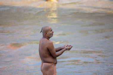 Rishikesh, Uttarakhand, Hindistan - Ekim 2022: Tanımlanamayan bir Hindu preist Rishikesh 'te Ganga nehri yakınlarında hindu ayinleri yapıyor..