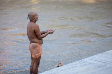 Rishikesh, Uttarakhand, Hindistan - Ekim 2022: Tanımlanamayan bir Hindu preist Rishikesh 'te Ganga nehri yakınlarında hindu ayinleri yapıyor..