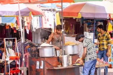 Rishikesh, Uttarakhand, Hindistan - Ekim 2022: Sokak Satıcısı, Kimliği belirsiz bir sokak satıcısının portresi Rishikesh caddesinde yemek hazırlıyor.