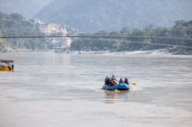 Rishikesh, Uttarakhand, Hindistan - Ekim 2022: Nehir raftingi, kimliği belirlenemeyen bir grup insan, rishikesh 'te nehir kenarındaki rafting yapıyor. Rishikesh yoga ile birlikte rafting yapmasıyla ünlüdür..