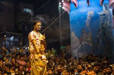 Varanasi, Uttar Pradesh, Hindistan - Kasım 2022: Ganga aarti, Dashashwamedh Ghat 'ta akşamüstü sanatan hindu ayinleriyle geleneksel elbise giymiş genç bir rahibin portresi.