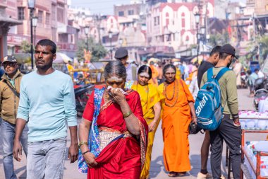Varanasi, Uttar Pradesh, Hindistan - Kasım 2022: Geleneksel elbise içinde Varanasi şehrinde nehir çetelerinin yakınındaki ghat üzerinde yürüyen kimliği belirsiz Hintli kadın Sadhvi 'nin portresi. Varanasi en eski ve kutsal şehirdir..