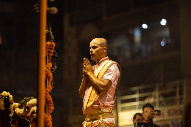 Varanasi, Uttar Pradesh, Hindistan - Kasım 2022: Ganga aarti, Dashashwamedh Ghat 'ta akşamüstü sanatan hindu ayinleriyle geleneksel elbise giymiş genç bir rahibin portresi.