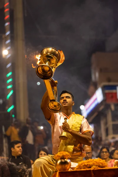 Varanasi, Uttar Pradesh, Hindistan - Kasım 2022: Ganga aarti, Dashashwamedh Ghat 'ta akşamüstü sanatan hindu ayinleriyle geleneksel elbise giymiş genç bir rahibin portresi.