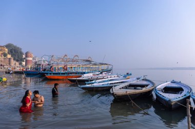 Varanasi, Uttar Pradesh, Hindistan - Kasım 2022: Antik binanın mimarisi, Tarihi Varanasi kenti, Assi ghat 'ta antik tapınaklar ve binalar mimarisi ve nehirdeki ahşap tekne.