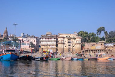 Varanasi, Uttar Pradesh, Hindistan - Kasım 2022: Antik binanın mimarisi, Tarihi Varanasi kenti, Assi ghat 'ta antik tapınaklar ve binalar mimarisi ve nehirdeki ahşap tekne.