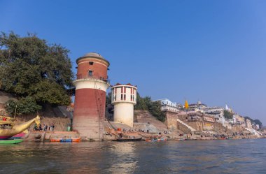 Varanasi, Uttar Pradesh, Hindistan - Kasım 2022: Antik binanın mimarisi, Tarihi Varanasi kenti, Assi ghat 'ta antik tapınaklar ve binalar mimarisi ve nehirdeki ahşap tekne.