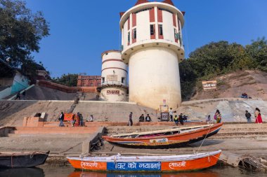 Varanasi, Uttar Pradesh, Hindistan - Kasım 2022: Antik binanın mimarisi, Tarihi Varanasi kenti, Assi ghat 'ta antik tapınaklar ve binalar mimarisi ve nehirdeki ahşap tekne.