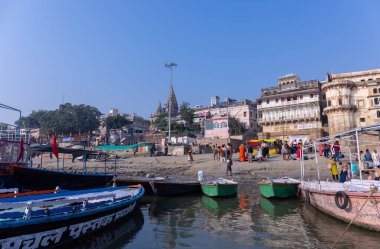 Varanasi, Uttar Pradesh, Hindistan - Kasım 2022: Antik binanın mimarisi, Tarihi Varanasi kenti, Assi ghat 'ta antik tapınaklar ve binalar mimarisi ve nehirdeki ahşap tekne.