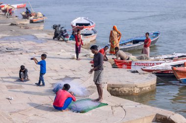 Varanasi, Uttar Pradesh, Hindistan - Kasım 2022: Balıkçılar, nehir çetelerinin yanında duran balıkçıların portresi.