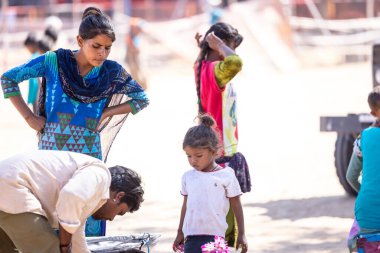 Puşkar, Rajasthan, Hindistan - Kasım 2022: Puşkar Fuarı, panayırda renkli elbiselerle gezen genç çocukların portresi.