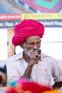 Puşkar, Rajasthan, Hindistan - Kasım 2022: Puşkar Fuarı, Rajasthani 'nin beyaz geleneksel elbisesi ve renkli sarıklı portresi.