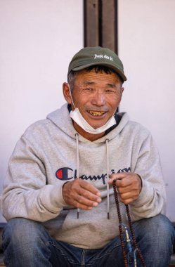 Sarnath, Uttar Pradesh, Hindistan - Kasım 2022: Tibbet 'ten gülümseyen yüzlü yaşlı bir adamın portresi.