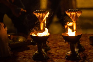 Varanasi, Uttar Pradesh, Hindistan - Kasım 2022: Ganga aarti, genç bir rahibin portresi, Assi Ghat 'ta akşam üzeri ateş ve ayinlerle geleneksel elbise giymiş nehir çetelerini icra ediyor..