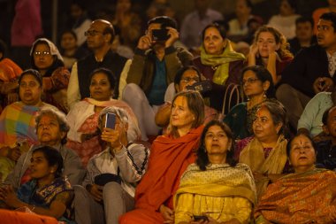Varanasi, Uttar Pradesh, Hindistan - Kasım 2022: Ganga aarti, genç bir rahibin portresi, Assi Ghat 'ta akşam üzeri ateş ve ayinlerle geleneksel elbise giymiş nehir çetelerini icra ediyor..