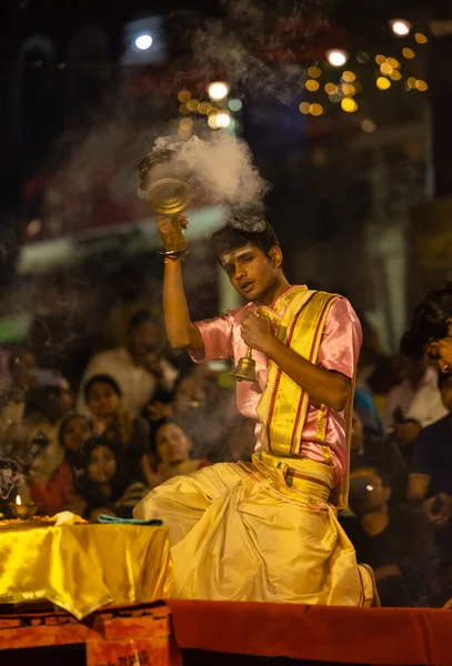 stock image Varanasi, Uttar Pradesh, India - November 2022: Ganga aarti, Portrait of an young priest performing river ganges evening aarti at assi Ghat in traditional dress with fire flame and rituals.