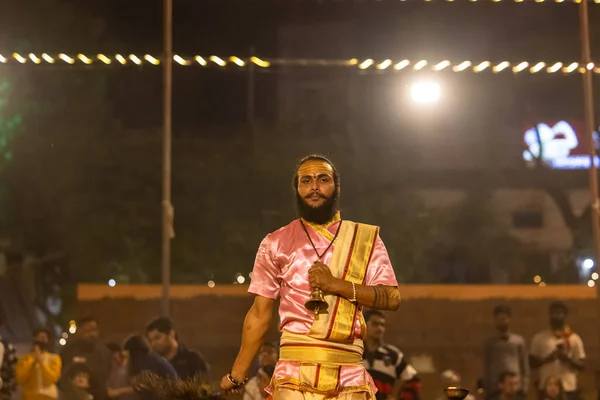 stock image Varanasi, Uttar Pradesh, India - November 2022: Ganga aarti, Portrait of an young priest performing river ganges evening aarti at assi Ghat in traditional dress with fire flame and rituals.