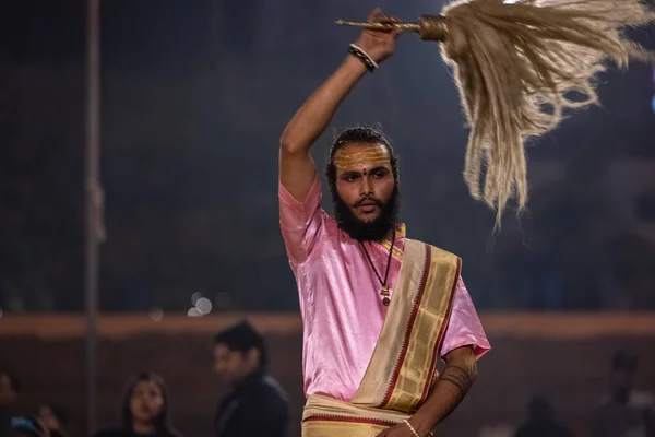 stock image Varanasi, Uttar Pradesh, India - November 2022: Ganga aarti, Portrait of an young priest performing river ganges evening aarti at Assi Ghat in traditional dress with fire flame and rituals.