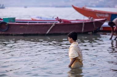 Varanasi, Uttar Pradesh, Hindistan - Kasım 2022: Ganj nehrinde Hintli çocuk 