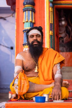 Varanasi, Uttar Pradesh, Hindistan - 20 Kasım 2022: Varanasi şehrinde geleneksel elbise içinde nehir çeteleri yakınlarındaki ghatlarda tanımlanamayan Hint kutsal sadhu erkek resimleri.