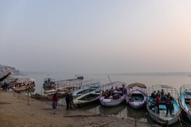 Varanasi, Uttar Pradesh, Hindistan - Kasım 2022: Ganj nehrine demirlemiş ahşap kayıklar 