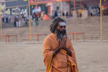 Varanasi, Uttar Pradesh, Hindistan - Kasım 2022: Tanınmayan Hint sadhu baba 'nın portresi gün doğumunda Varanasi şehrinde Ganj nehri kıyısındaki ghat üzerinde.