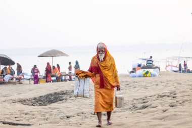Varanasi, Uttar Pradesh, Hindistan - Kasım 2022: Tanınmayan Hint sadhu baba 'nın portresi gün doğumunda Varanasi şehrinde Ganj nehri kıyısındaki ghat üzerinde.