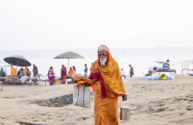 Varanasi, Uttar Pradesh, Hindistan - Kasım 2022: Tanınmayan Hint sadhu baba 'nın portresi gün doğumunda Varanasi şehrinde Ganj nehri kıyısındaki ghat üzerinde.