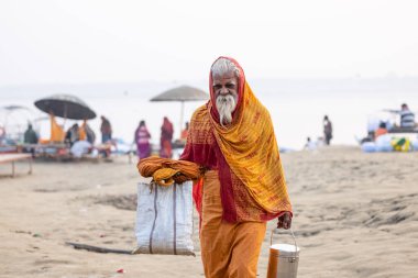 Varanasi, Uttar Pradesh, Hindistan - Kasım 2022: Tanınmayan Hint sadhu baba 'nın portresi gün doğumunda Varanasi şehrinde Ganj nehri kıyısındaki ghat üzerinde.