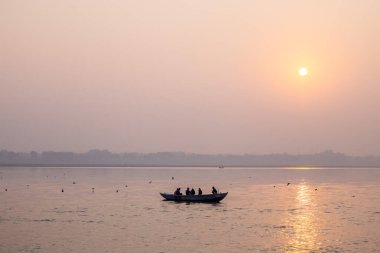 Varanasi, Uttar Pradesh, Hindistan - Kasım 2022: Turistler, Varanasi 'deki martı sürüsüyle birlikte nehir çetelerinde tekne gezintisinin keyfini çıkarıyorlar.