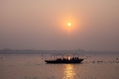 Varanasi, Uttar Pradesh, Hindistan - Kasım 2022: Gece vakti turistlerle birlikte nehir çetelerinde hafif araçlarla gezen ahşap tekne.