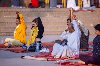 Varanasi, Uttar Pradesh, Hindistan - 20 Kasım 2022: birlikte meditasyon yapan insanlar