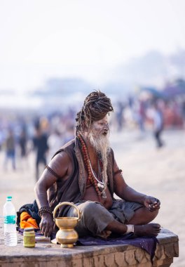 Varanasi, Uttar Pradesh, Hindistan - Kasım 2022: Tanınmayan Hint sadhu baba 'nın portresi gün doğumunda Varanasi şehrinde Ganj nehri kıyısındaki ghat üzerinde.