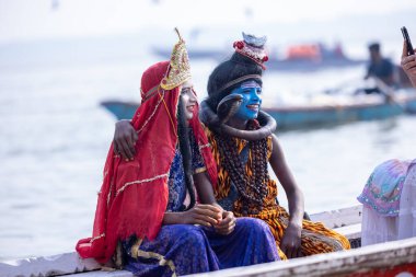 Varanasi, Uttar Pradesh, Hindistan - 20 Kasım 2022: Lord Shiva ve tanrıça Parvati gibi giyinen genç bir çocuğun portresi.